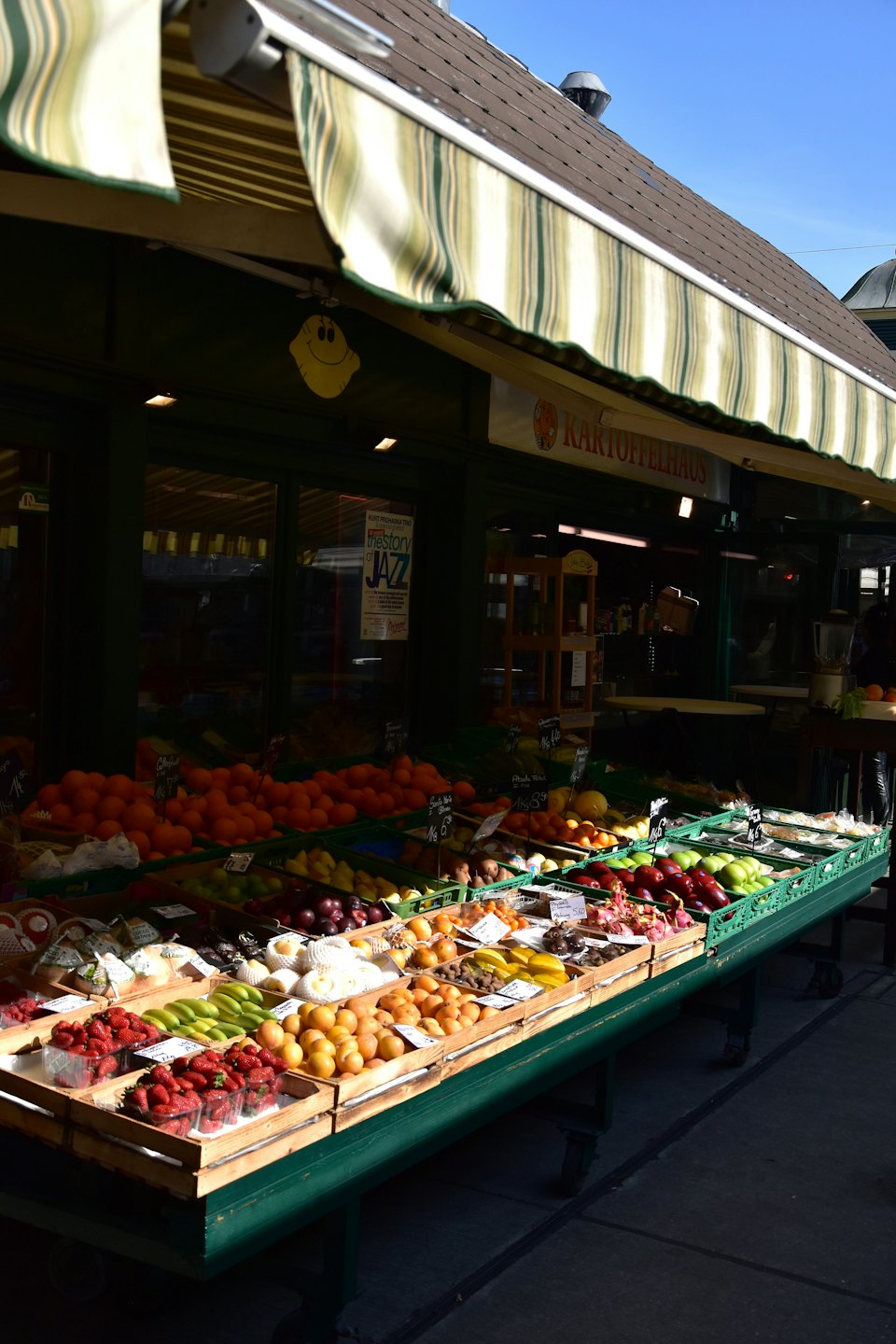 Outdoor fruit stand overflowing with colorful fresh produce.